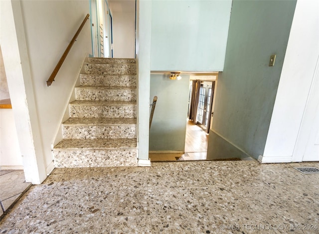 stairs with french doors, a high ceiling, and visible vents