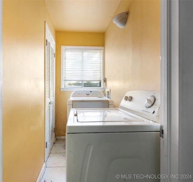 laundry room featuring laundry area, washing machine and clothes dryer, and light tile patterned floors