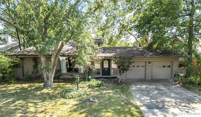 single story home featuring an attached garage, a front lawn, concrete driveway, and brick siding