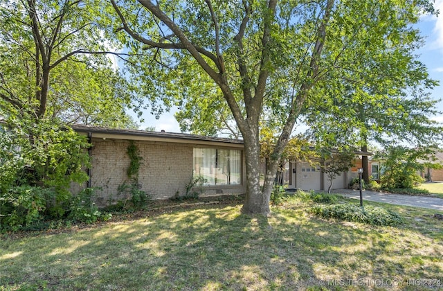 view of front facade with an attached garage, brick siding, driveway, crawl space, and a front yard