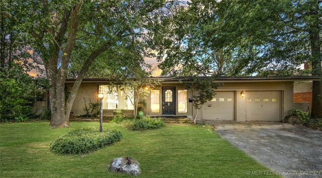 view of front of house featuring a garage and a yard