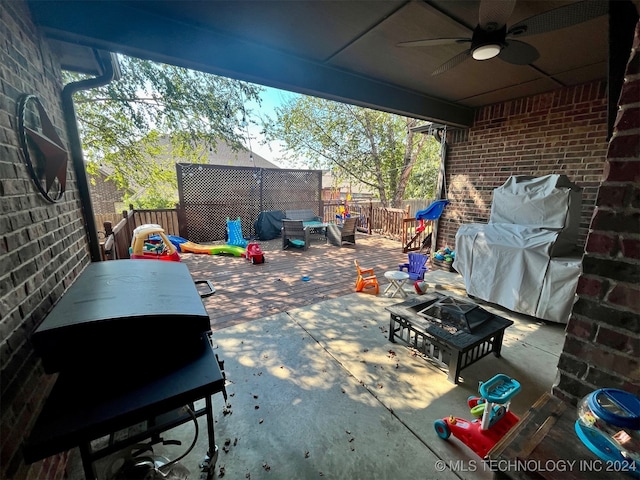 view of patio with grilling area, ceiling fan, and an outdoor living space with a fire pit