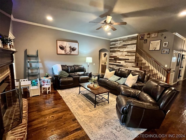 living room with crown molding, hardwood / wood-style flooring, a brick fireplace, and ceiling fan