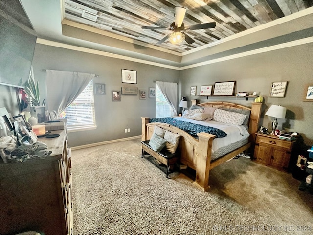 bedroom with crown molding, a raised ceiling, ceiling fan, and carpet floors