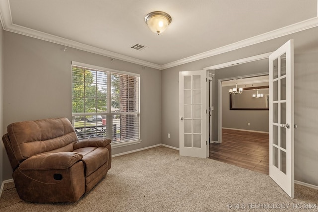 sitting room featuring carpet, a chandelier, ornamental molding, and french doors