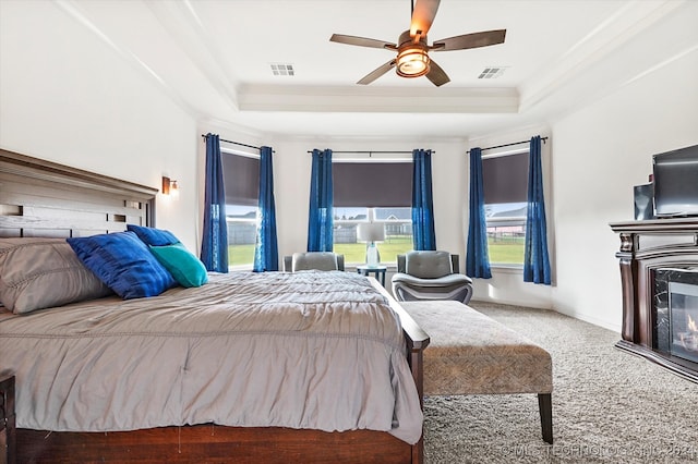 bedroom featuring ceiling fan, carpet, a tray ceiling, and crown molding