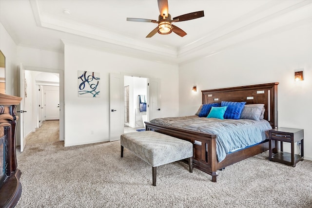 carpeted bedroom featuring ceiling fan and a raised ceiling