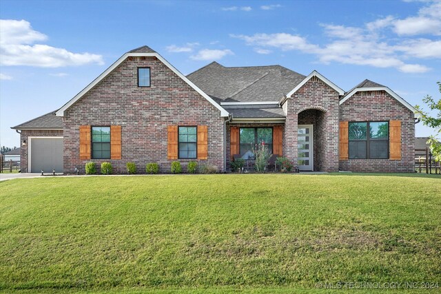 view of front of property featuring a front lawn and a garage