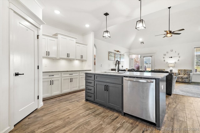 kitchen featuring tasteful backsplash, white cabinets, dishwasher, and sink