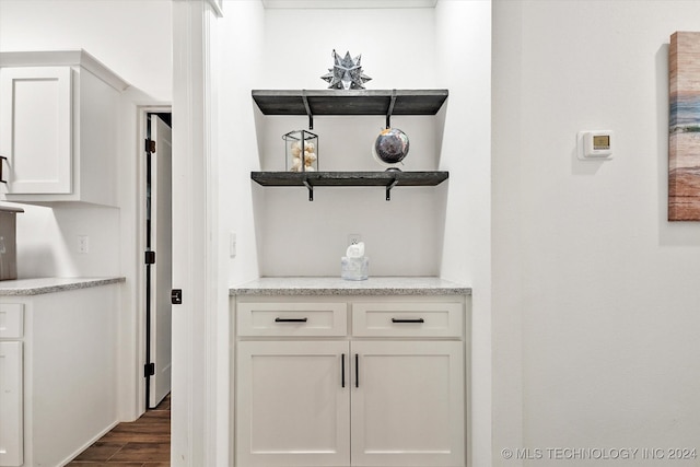 bar featuring white cabinets and dark wood-type flooring