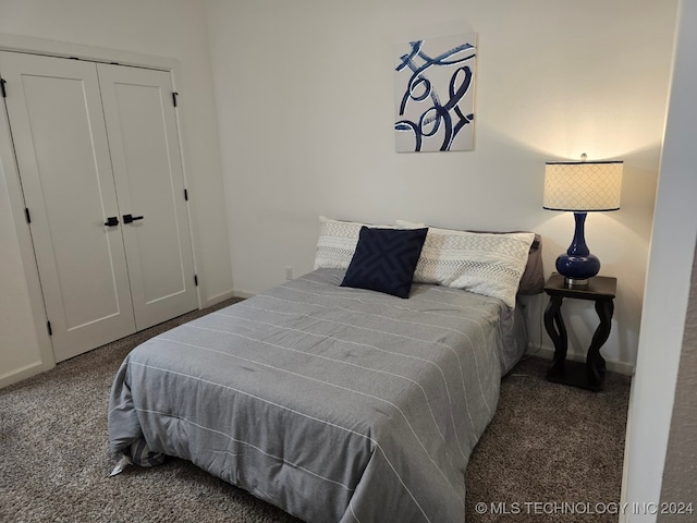 bedroom with a closet and dark carpet