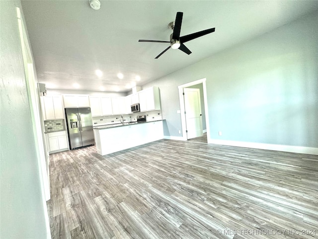 unfurnished living room with ceiling fan, hardwood / wood-style flooring, and sink