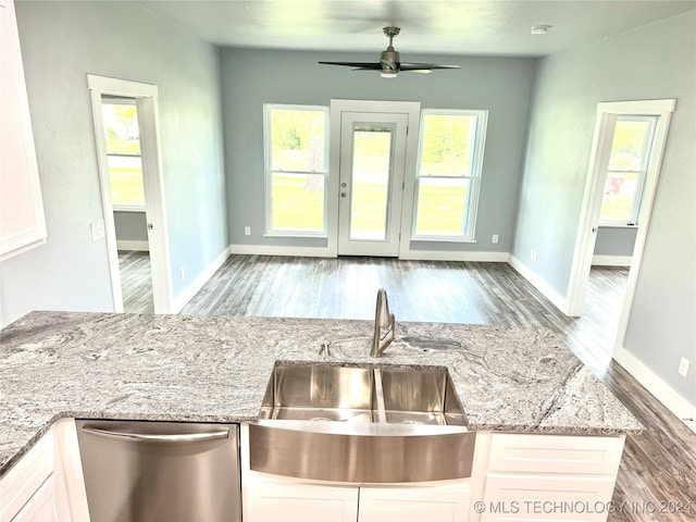 kitchen featuring a wealth of natural light, stainless steel dishwasher, ceiling fan, and white cabinets