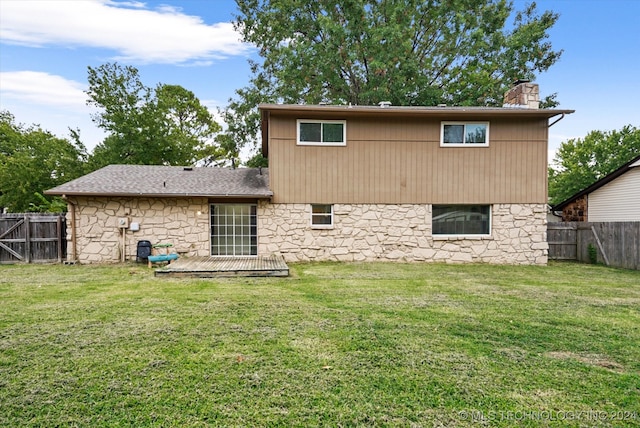 rear view of house featuring a lawn