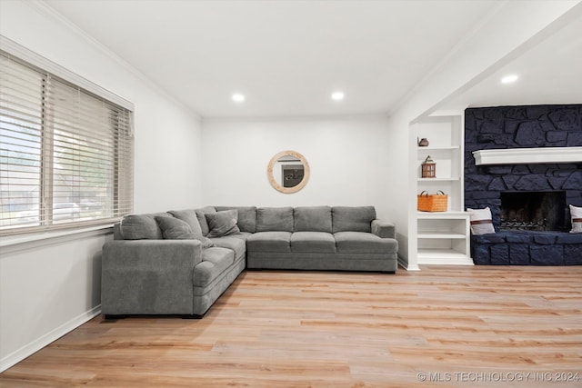 living room with ornamental molding, a fireplace, and light hardwood / wood-style floors