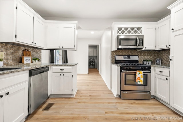 kitchen with light stone counters, white cabinets, appliances with stainless steel finishes, and light wood-type flooring