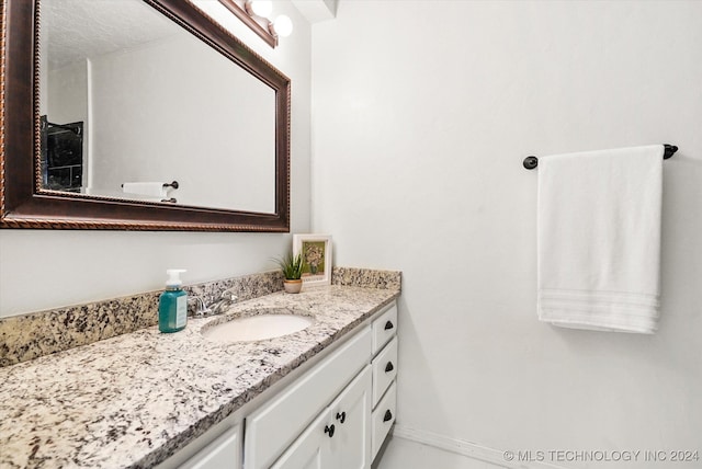 bathroom with a textured ceiling and vanity