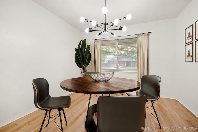 dining space with a notable chandelier and light hardwood / wood-style flooring