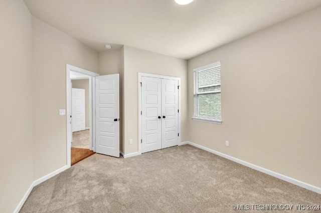 unfurnished bedroom with a closet and light carpet