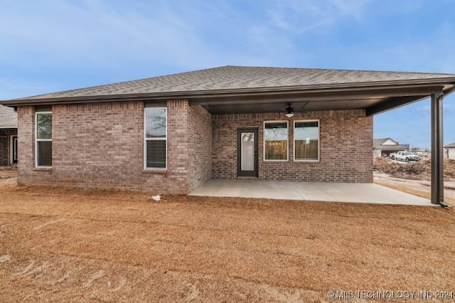 rear view of house with ceiling fan, a yard, and a patio