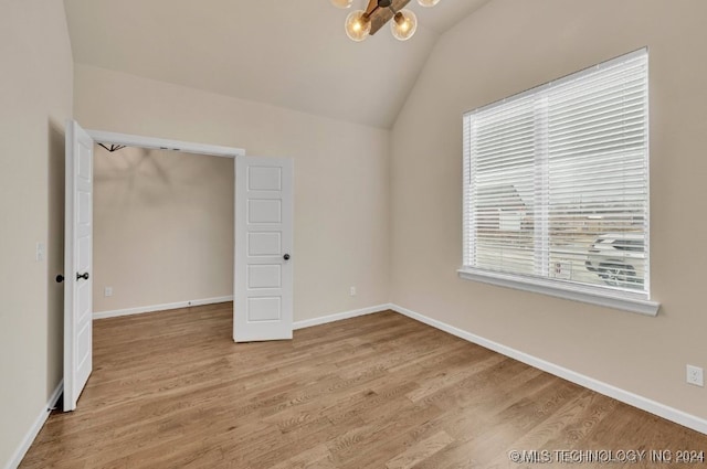 unfurnished bedroom featuring a closet, wood-type flooring, a chandelier, and vaulted ceiling