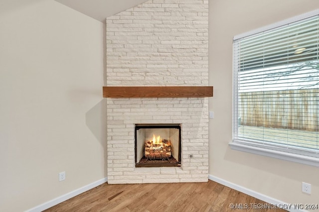 interior details with hardwood / wood-style floors and a brick fireplace