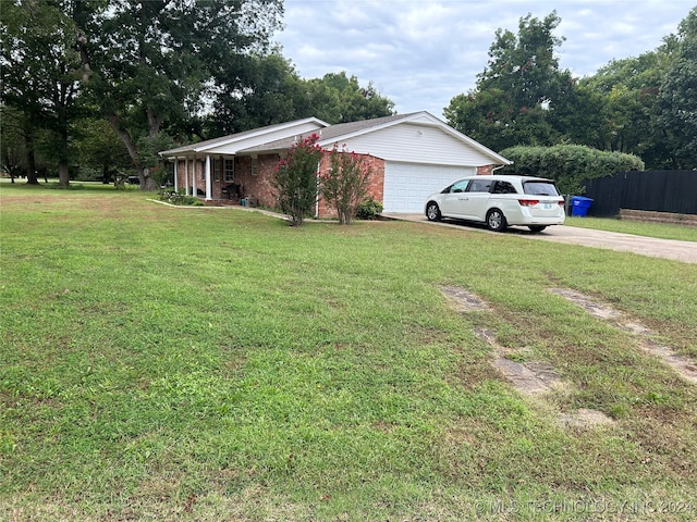 view of side of property featuring a garage and a lawn