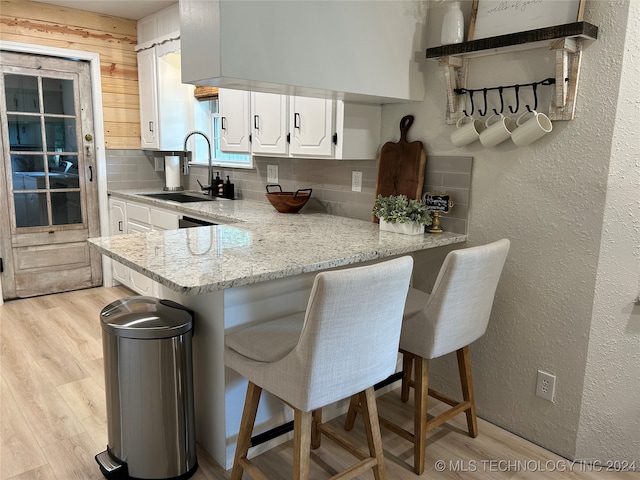 kitchen featuring kitchen peninsula, a kitchen breakfast bar, and sink