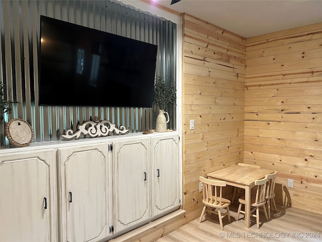 interior space with hardwood / wood-style flooring and wooden walls