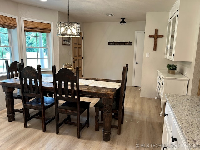 dining room featuring light wood-type flooring and a chandelier