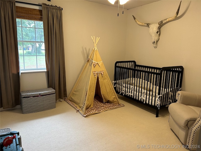 carpeted bedroom featuring a crib