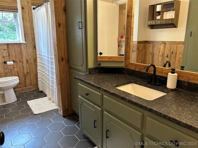 bathroom with vanity, toilet, curtained shower, and wooden walls