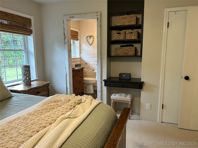 bedroom with carpet flooring and connected bathroom