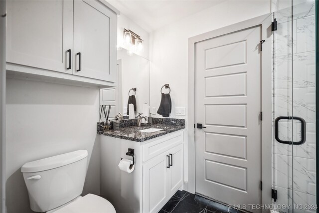 bathroom featuring vanity, toilet, and an enclosed shower