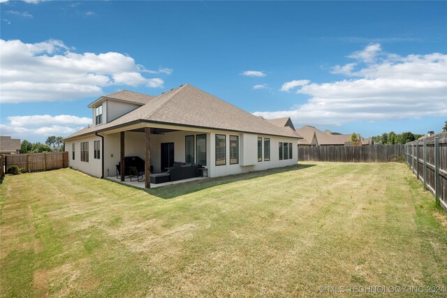 back of property with a yard, a patio area, and outdoor lounge area