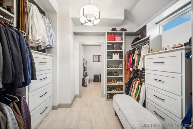 spacious closet with a chandelier