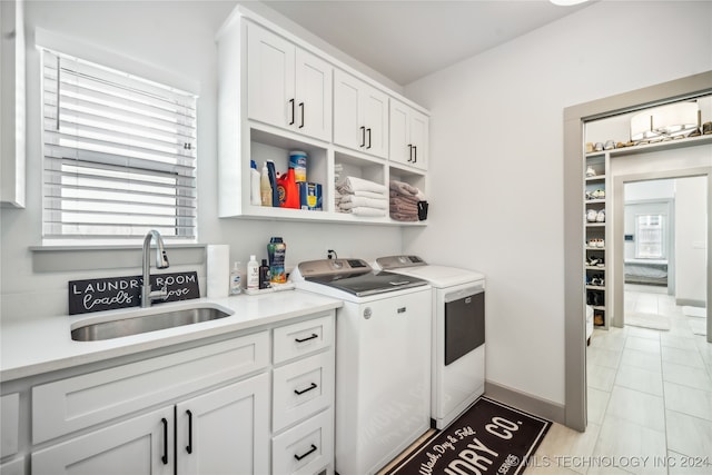 kitchen with separate washer and dryer, sink, and white cabinets