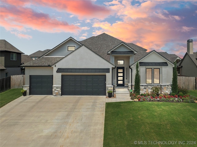 view of front of home with fence, roof with shingles, a standing seam roof, an attached garage, and a yard