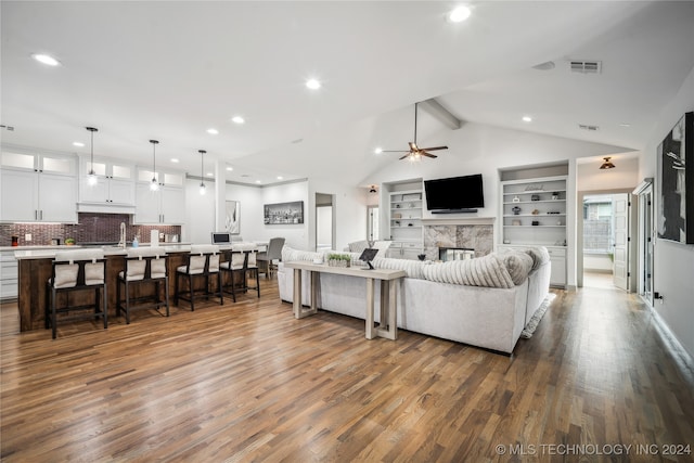 living room featuring a premium fireplace, ceiling fan, vaulted ceiling with beams, and dark wood-type flooring