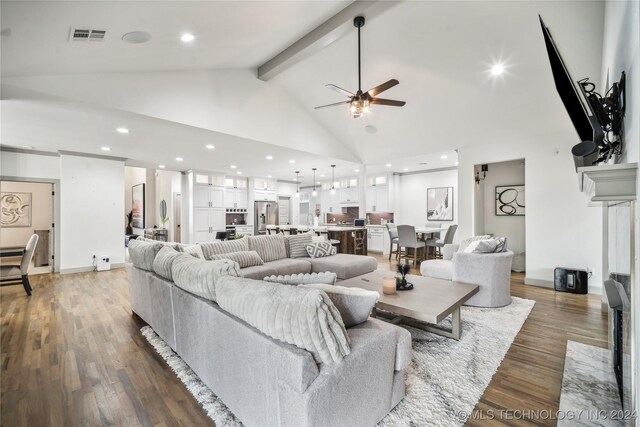 living room featuring a high end fireplace, dark wood-type flooring, beam ceiling, and ceiling fan