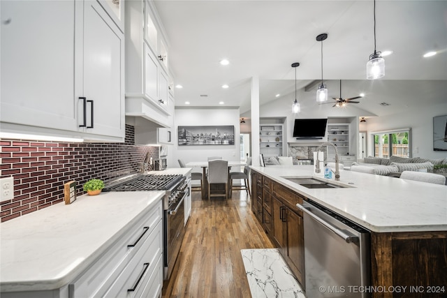 kitchen featuring white cabinets, stainless steel appliances, a kitchen island with sink, and sink