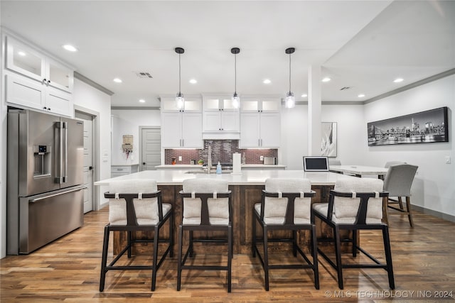 kitchen with wood-type flooring, backsplash, white cabinetry, and high quality fridge