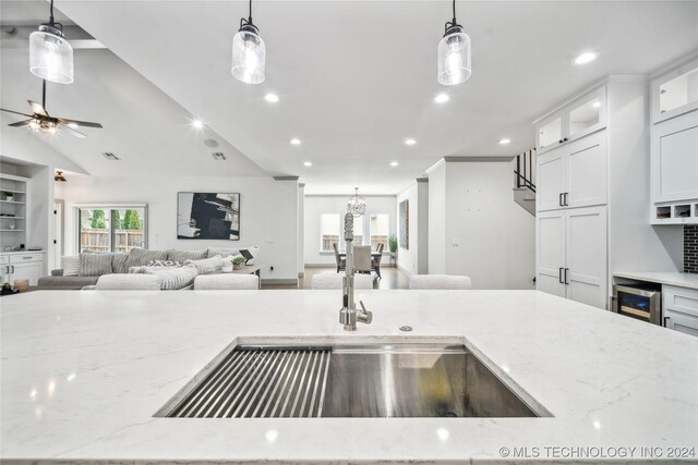 kitchen featuring pendant lighting, ceiling fan, and light stone counters