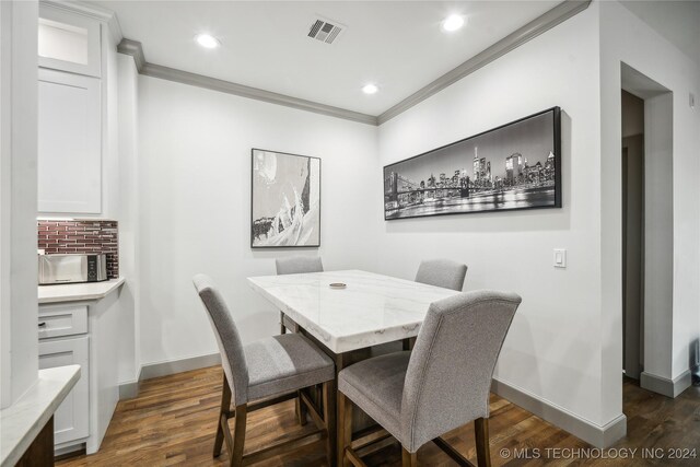 dining area featuring crown molding and dark hardwood / wood-style flooring