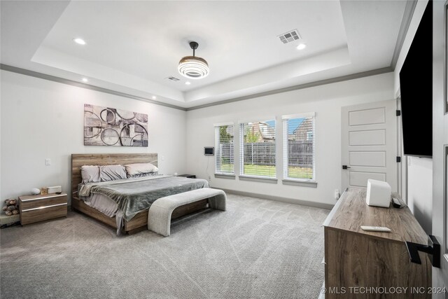 carpeted bedroom featuring crown molding, a raised ceiling, and ceiling fan