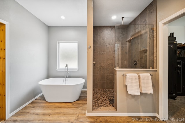 bathroom featuring separate shower and tub and hardwood / wood-style flooring