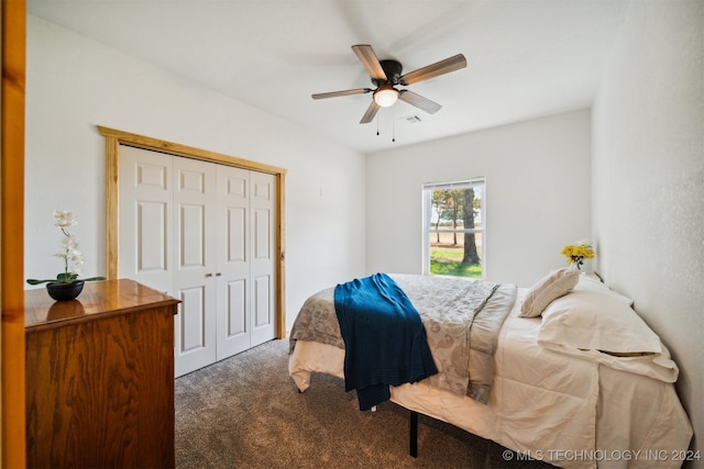 bedroom with dark carpet, ceiling fan, and a closet