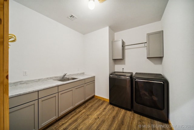 washroom featuring dark hardwood / wood-style floors, cabinets, sink, and separate washer and dryer