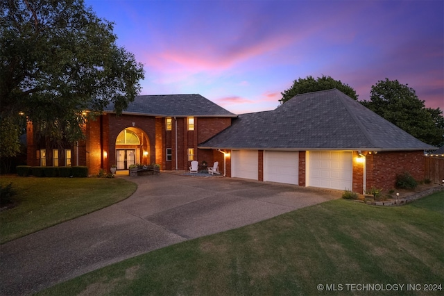 view of front of home with a garage and a lawn