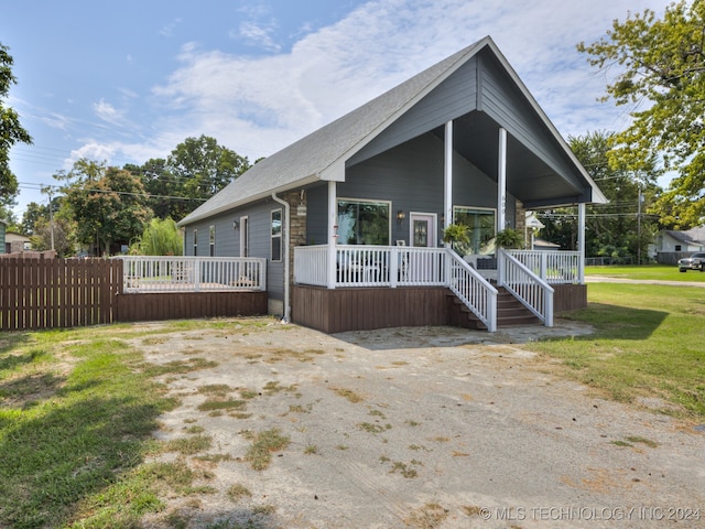 view of front of property featuring covered porch and a front lawn